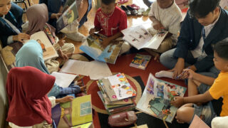 sekelompok siswa tk dan sd membaca buku bersama